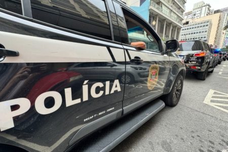 Imagem mostra viatura da Polícia Civil com o braço de um policial na janela - Metrópoles