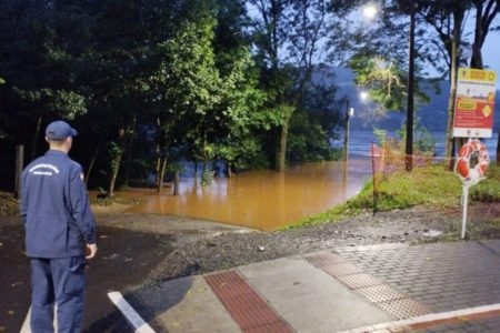 Foto colorida de homem olhando para travessia encoberta de água rio Uruguai - Metrópoles