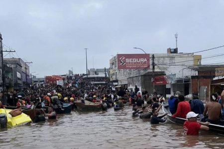 Foto colorida de pessoas em enchente na cidade de Canoas no Rio Grande do Sul - Metrópoles