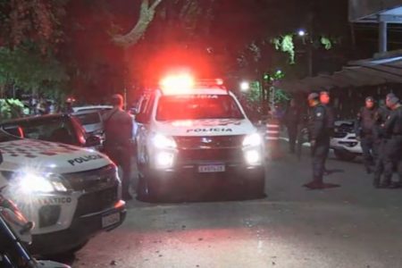 Imagem colorida de viaturas da PM cercada por homens, agentes da polícia militar - Metrópoles