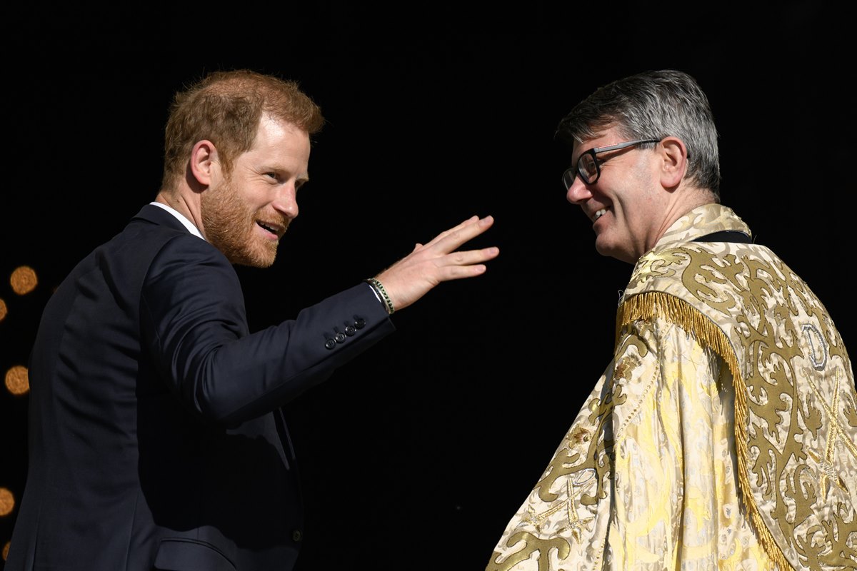 Foto colorida de homem ruivo conversando com homem com traje de bispo - Metrópoles