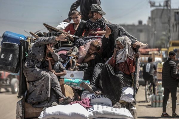 Imagem colorida mostra mulheres e crianças palestinas em uma carroceria de um caminhão fugindo de Rafah - Metrópoles