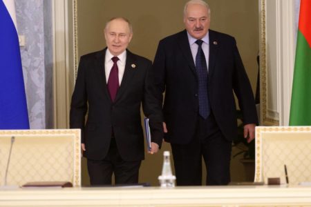 Imagem colorida mostra Putin e Lukashenko andando com as bandeiras da Rússia e Belarus ao lado - Metrópoles