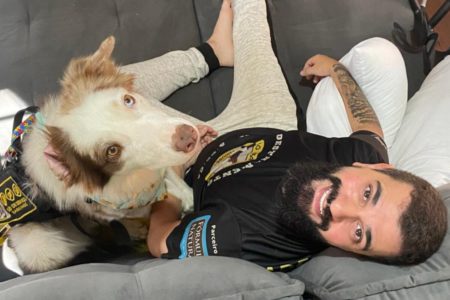 Foto de border collie ao lado de homem de barba em sofá - Metrópoles