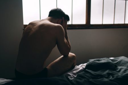 Foro colorida de homem sentado de cueca com as mãos na cabeça - Metrópoles