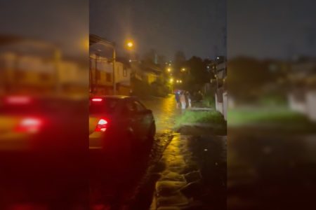 Imagem colorida de pessoas em rua à noite em Caxias do Sul - Metrópoles