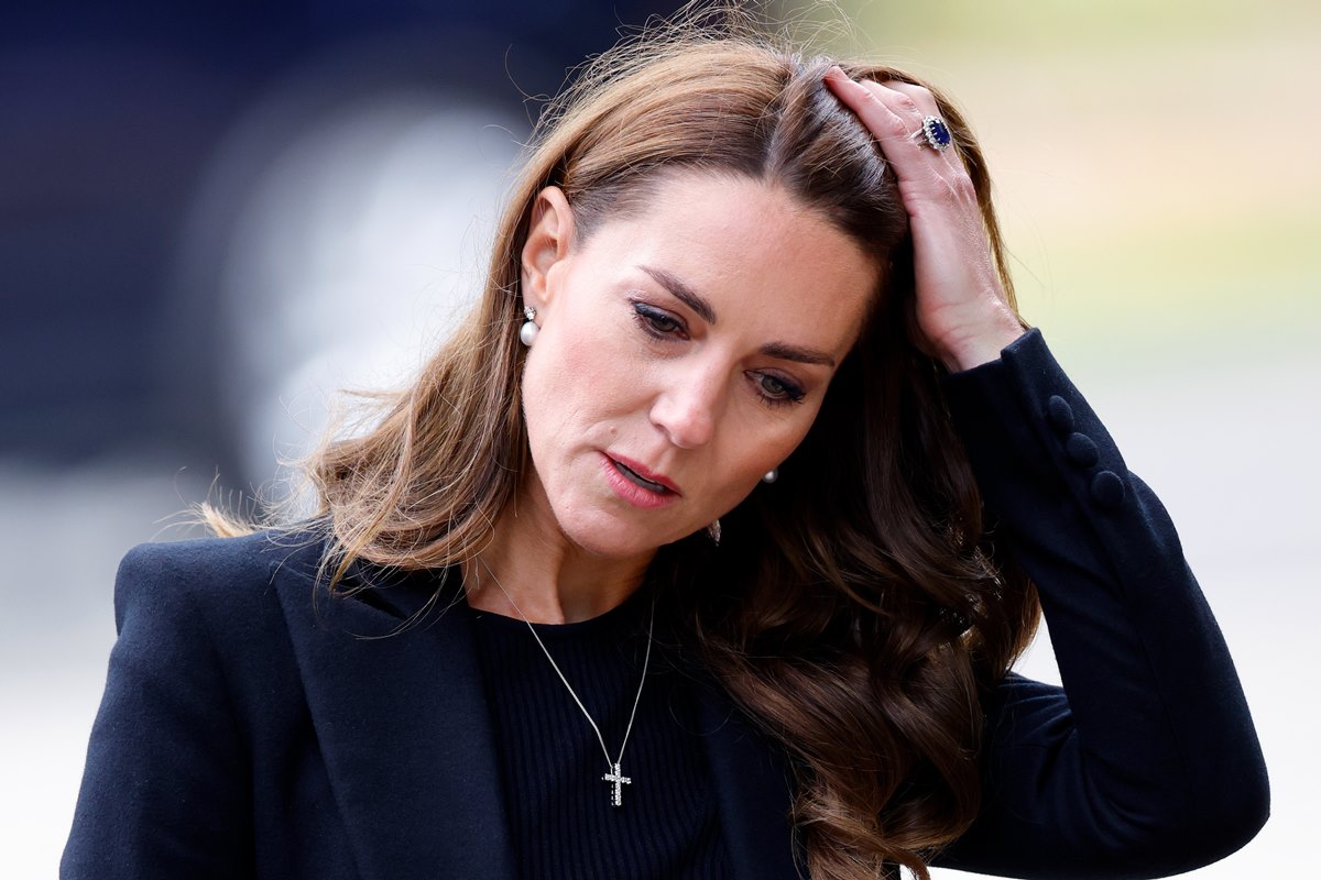 Foto colorida de mulher passando a mão no cabelo. Ela veste uma roupa preta - Metrópoles