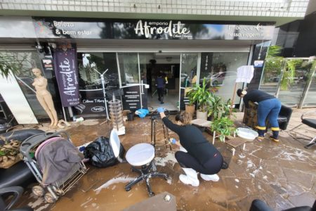 Imagem colorida de mutirão de limpeza em frente a comércio de Porto Alegre (RS) gaúchos se adaptam - desenrola Metrópoles