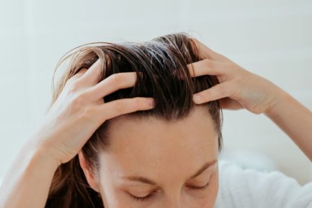 Foto colorida de uma mulher com a mão no cabelo - Metrópoles