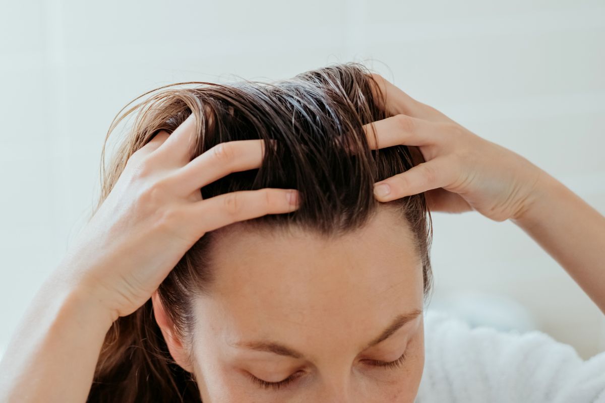 Foto colorida de uma mulher com a mão no cabelo - Metrópoles