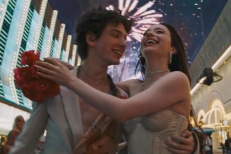 Imagem colorida de um homem e um mulher andando abraçados pela rua