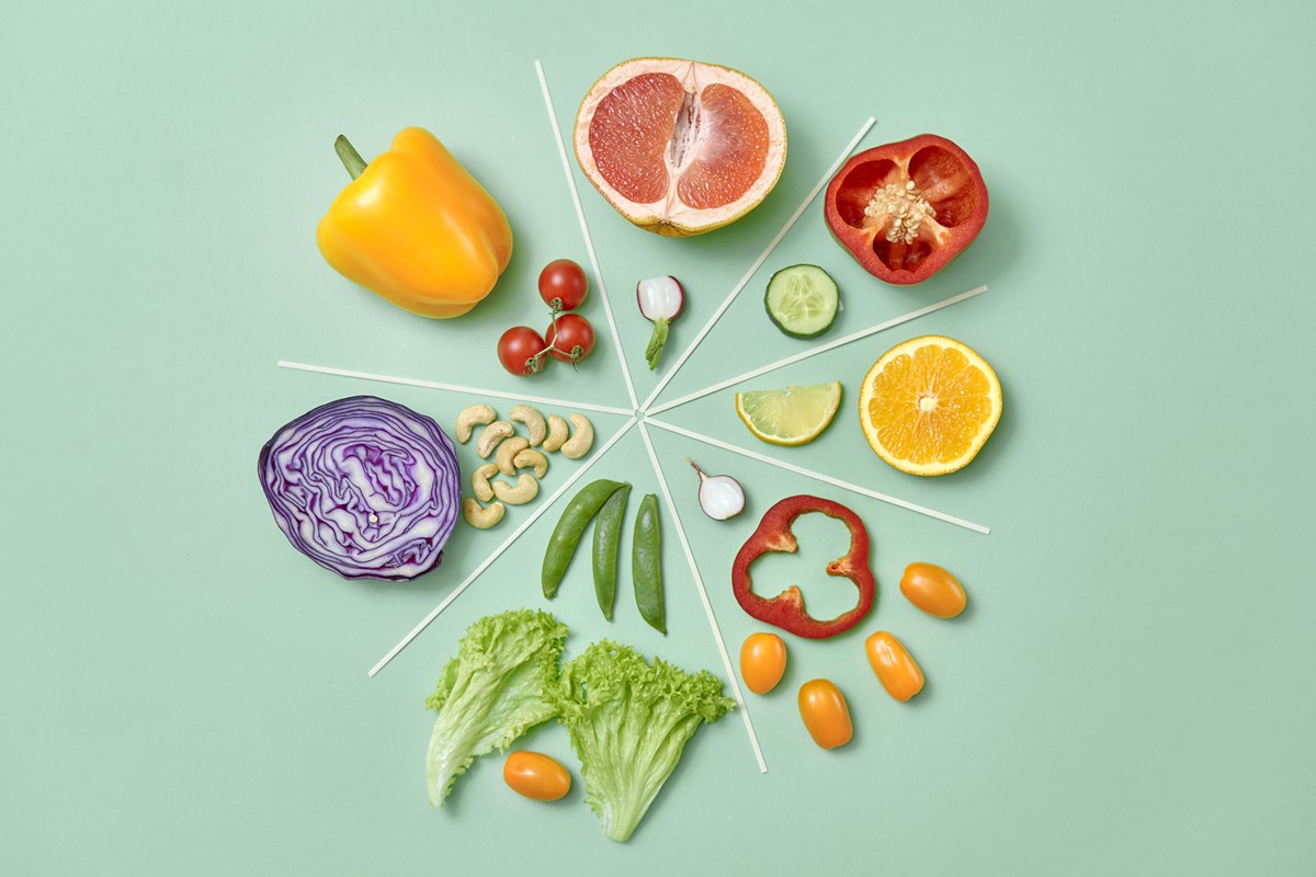 Foto colorida de frutas e vegetais em uma superfície verde - Metrópoles