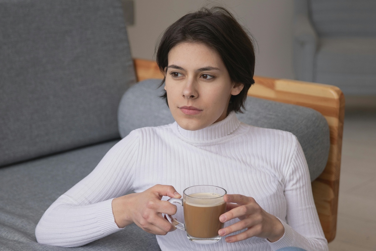 Jovem mulher segurando xícara de chocolate quente - Metrópoles