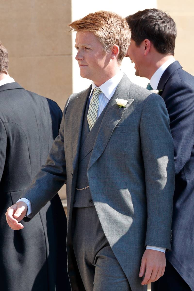 Foto colorida - Homem loiro chegando no casamento dos Duques de Sussex com um terno cinza