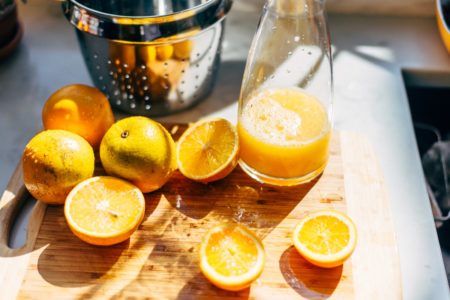 Laranjas cortadas para fazer suco em uma tábua - Metrópoles
