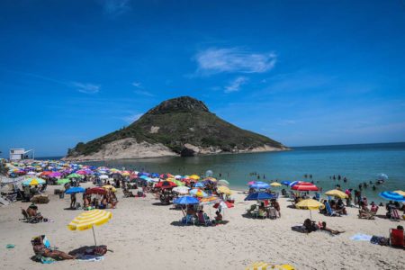 Imagem colorida mostra pessoas em praia do Rio de Janeiro - Metrópoles