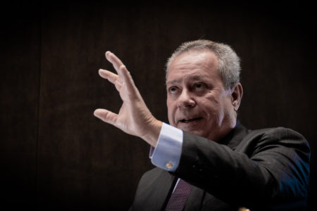 O presidente da Confederação Nacional da Indústria (CNI), Ricardo Alban, conversa com interlocutor e gesticula com a mão esquerda levantada