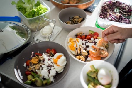 Uma mão aparece preparando um prato da dieta cetogênica, que é rica em proteínas - Metrópoles