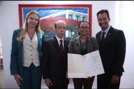 Imagem colorida de pessoas umas ao lado das outras. Uma mulher segura a escritura de uma casa títulos de propriedade - Metrópoles