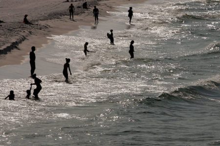 imagem colorida mostra pessoas em praia na florida ataques de tubarão - Metrópoles