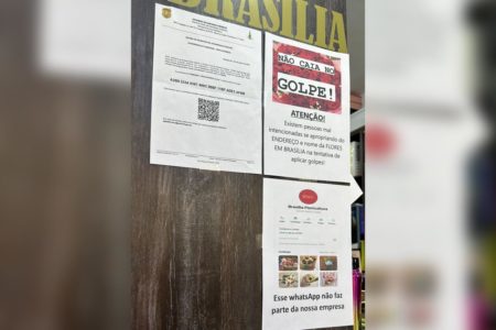 Imagem colorida de informes colados em porta de madeira - Metrópoles