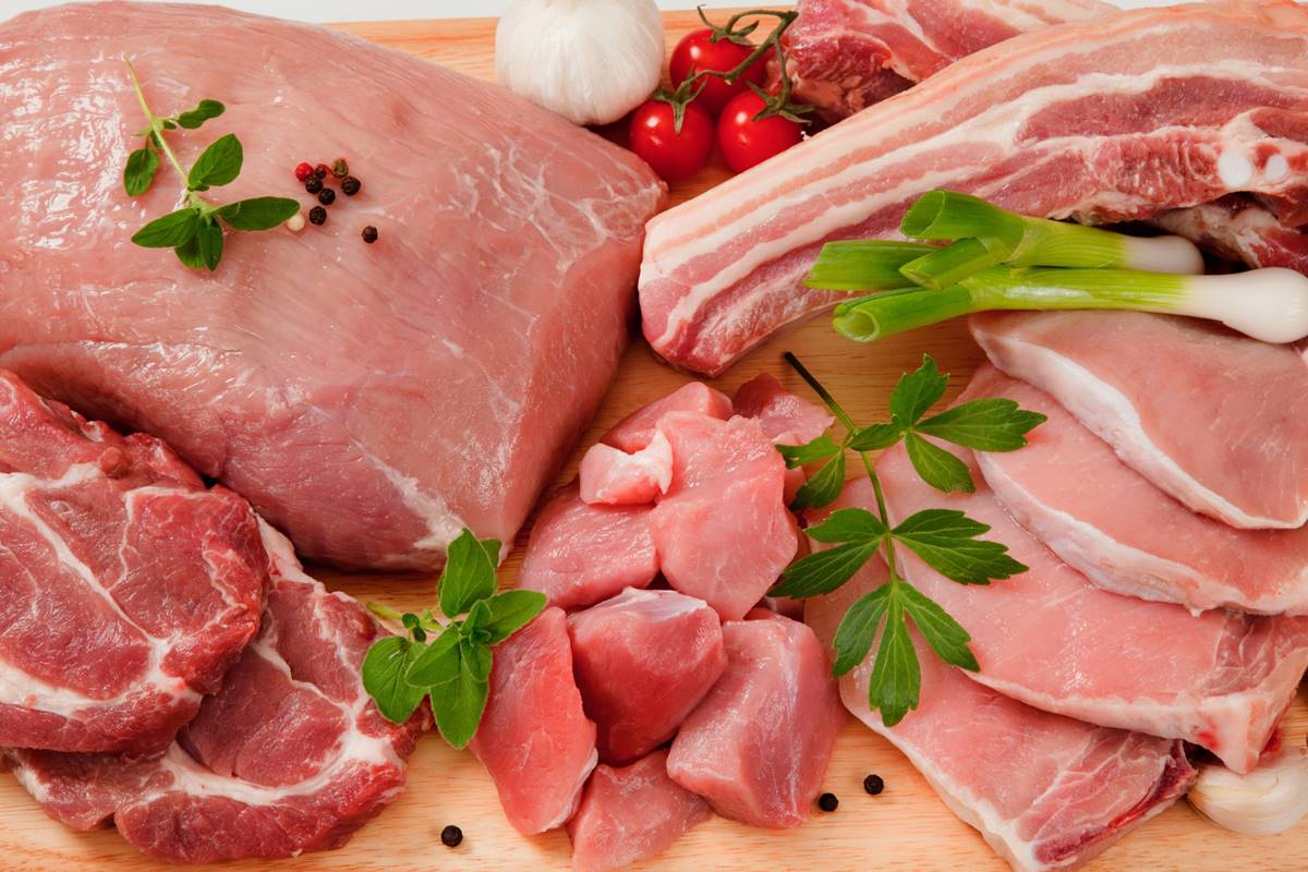 Foto colorida de cortes de carne suína em uma tábua de cortar - Metrópoles