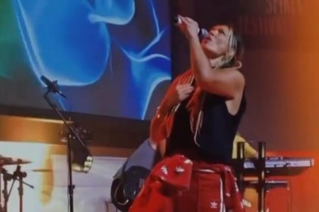 Imagem colorida mostra a cantora gospel Denise Seixas, uma mulher loira, cantando - Metrópoles