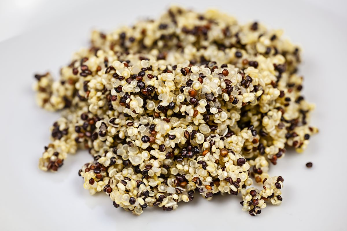Foto colorida - Grãos de quinoa amarelos, vermelhos e pretos