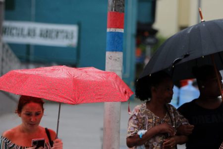 Imagem colorida de pessoas durante chuva em Santa Catarina - Metrópoles