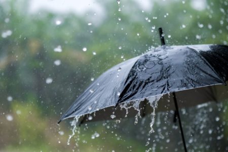 Imagem colorida de guarda-chuva em meio a chuva - Metrópoles
