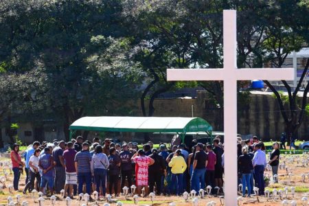 Foto colorida tirada de dia de velório em cemitério ao ar livre