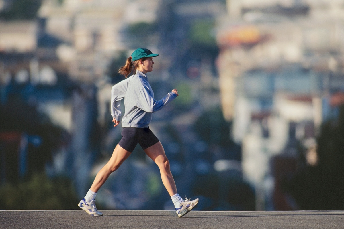 Foto de uma mulher jovem caminhando em área urbana