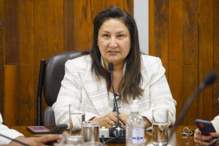 Imagem colorida mostra a vereadora Rute Costa, mulher parda, de cabelos lisos, vestindo blazer branco, em auditório da Câmara Municipal - Metróoles