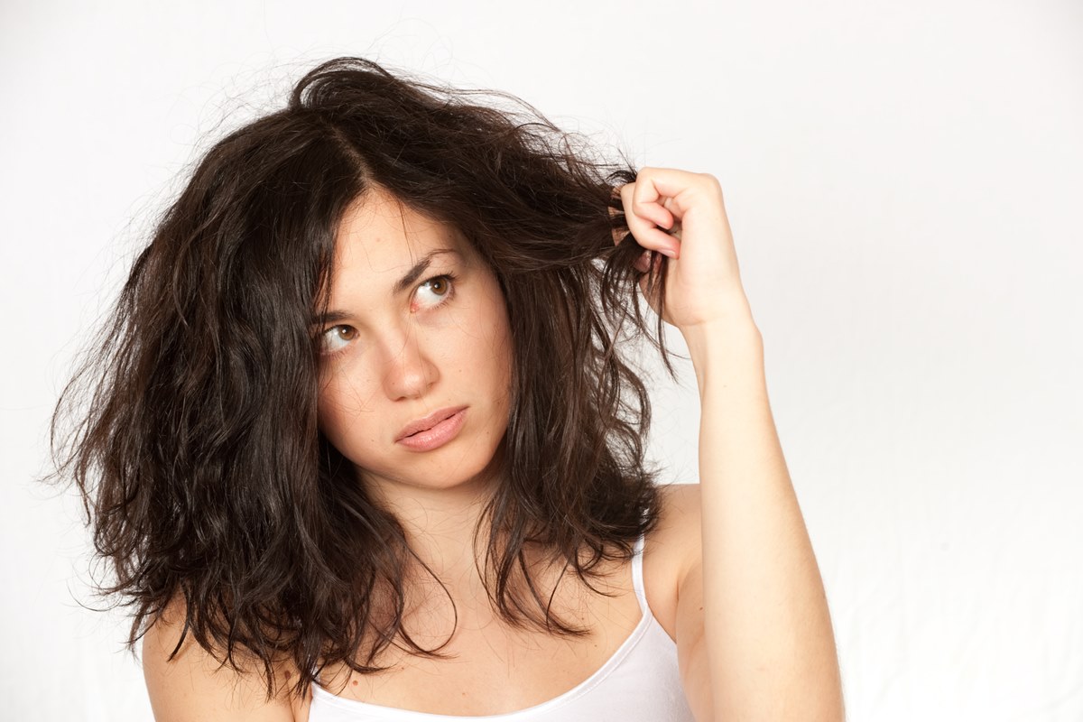 Foto colorida de mulher pegando no cabelo curto - Metrópoles