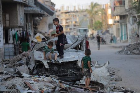 Imagem colorida mostra crianças em destroços na Faixa de Gaza - Metrópoles