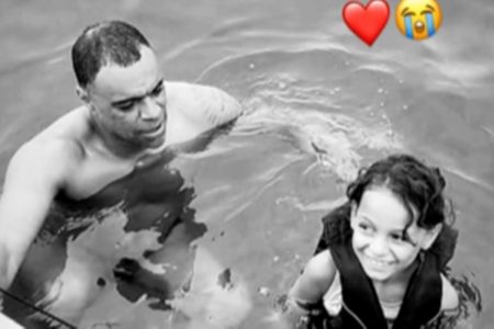 Na imagem em preto e branco, ex-jogador Denilson aparece ao lado da sobrinha Lorena, enquanto os dois nadam - Metrópoles