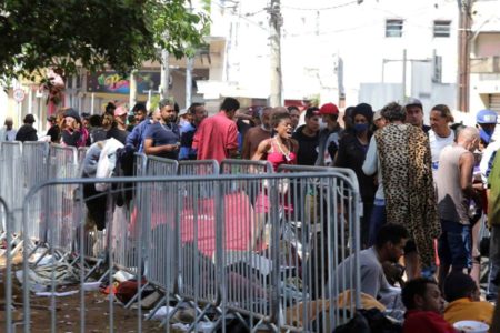 Imagem colorida mostra usuários da Cracolândia, no centro de São Paulo, com grades ao redor - Metrópoles