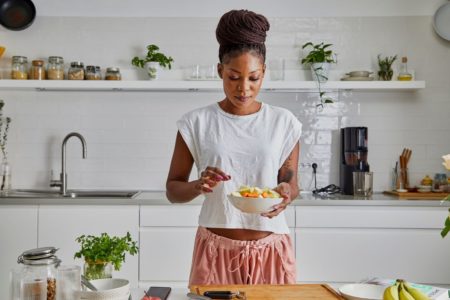 mulher colocando alimentos cortados em um bowl