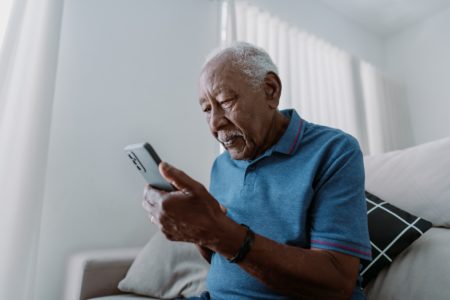 Idoso fala em telefone celular com expressão grave - Metrópoles - Alzheimer fala