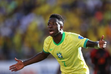 Imagem colorida de Vinícius Jr. de braços abertos - Metrópoles