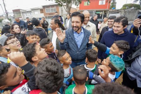 Imagem colorida mostra Ricardo Nunes rodeado por crianças - Metrópoles