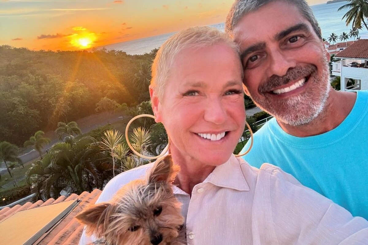 Xuxa e Junno Andrade posam juntos e sorridentes - Metrópoles