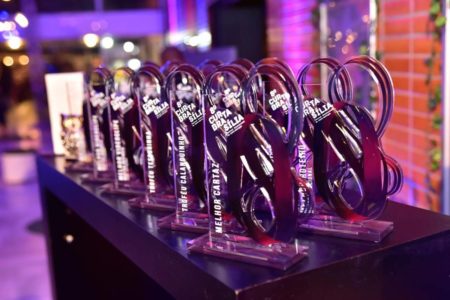 foto colorida de mesa com troféus - metrópoles