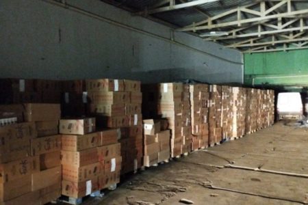 Imagem colorida mostra caixas de cigarro empilhadas em um galpão apreendidas pela PF - Metrópoles