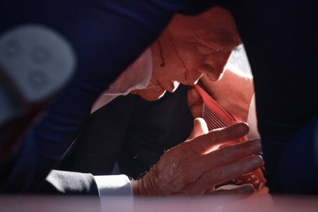 O candidato presidencial republicano, ex-presidente Donald Trump, é mostrado coberto por agentes do Serviço Secreto dos EUA após um incidente durante um comício em 13 de julho de 2024 em Butler, Pensilvânia