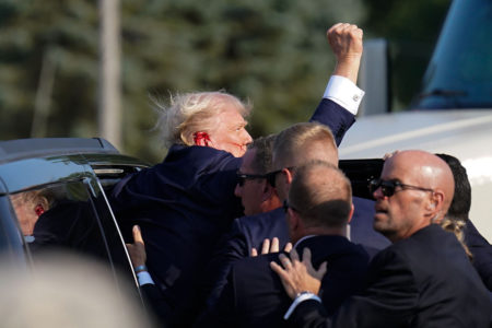 O ex-presidente Donald Trump, vítima de atentado, levanta o braço enquanto é ajudado a entrar em um veículo depois de comício de campanha interrompido no Butler Farm Show Inc. no sábado, 13 de julho de 2024 em Butler, Pensilvânia
