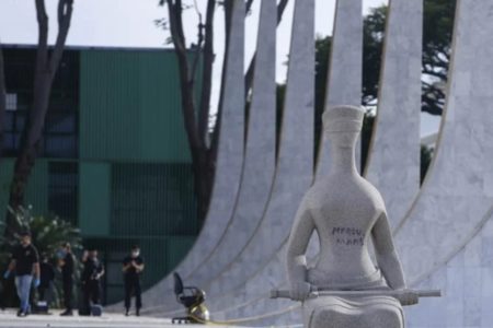 Imagem colorida de estátua do STF pichada -- Metrópoles