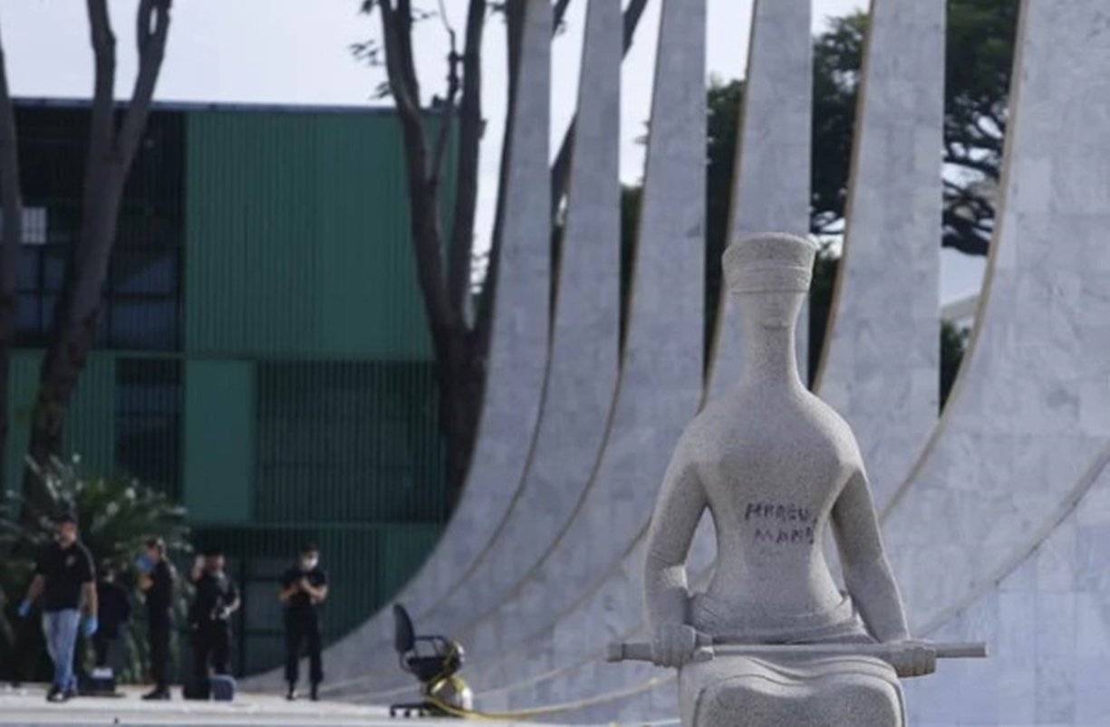 Imagem colorida de estátua do STF pichada