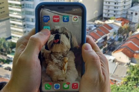 Imagem mostra celular com cidade ao fundo - Metrópoles
