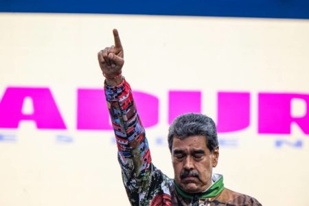 Imagem colorida mostra o presidente da Venezuela, Nicolás Maduro, com o braço levantado - Metrópoles